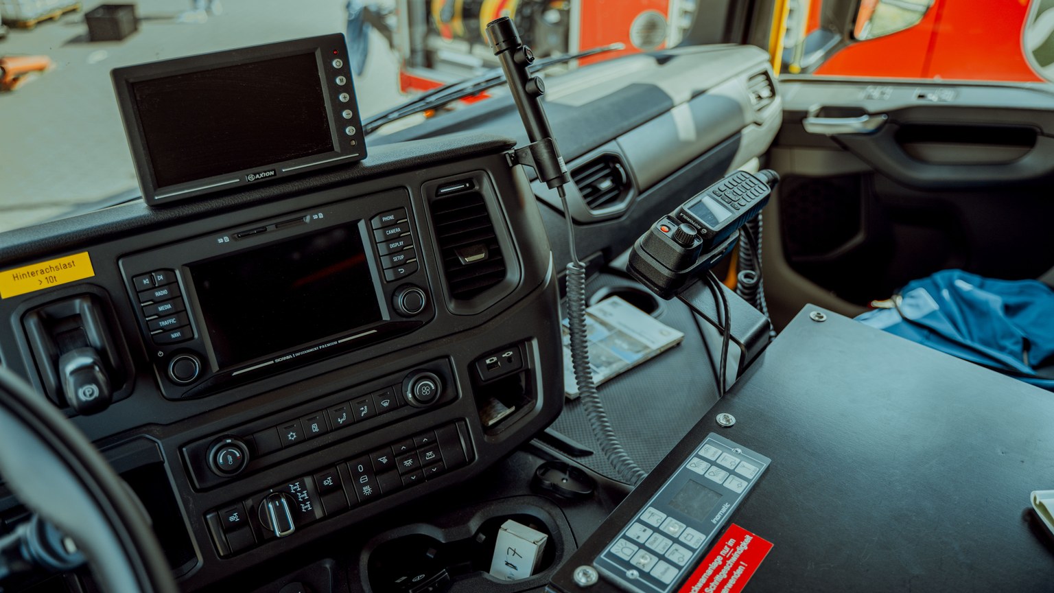 Detailed photo of a firetruck dashboard with communication devices and navigation screens.