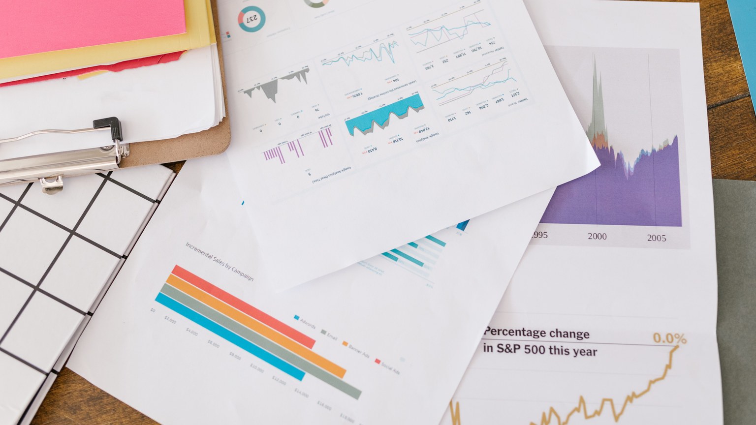 Close-up of business analytics charts and graphs on papers and clipboard.
