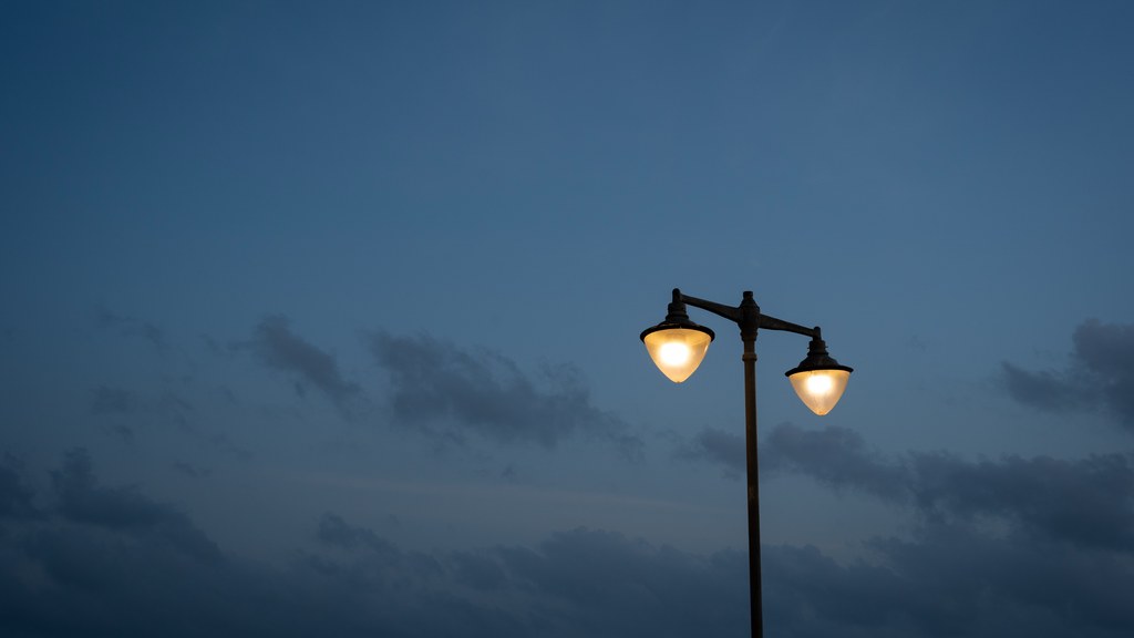 A street lamp illuminates against a twilight sky, creating a serene urban evening scene in Colombo, Sri Lanka.