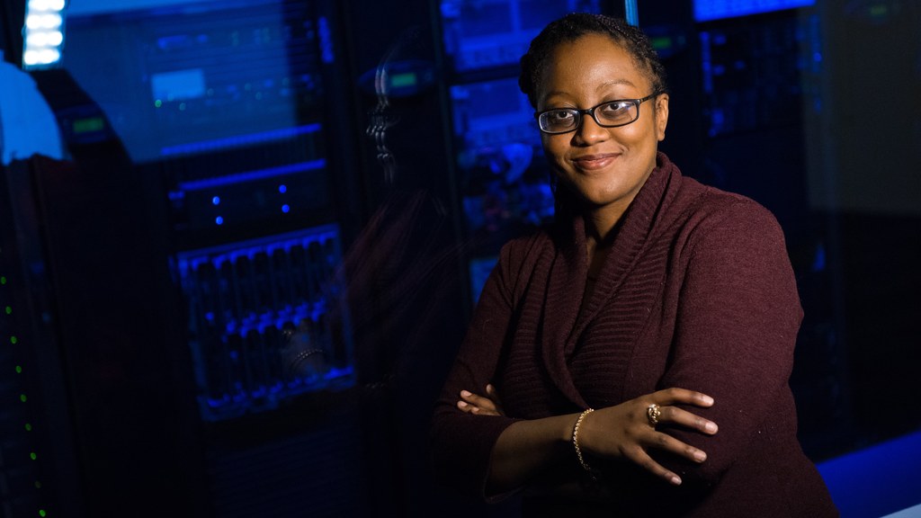 Confident woman in data center, showcasing tech expertise.