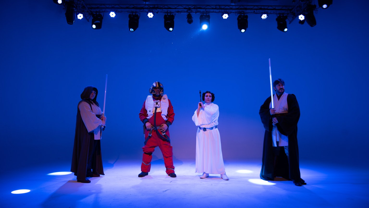 Group in Star Wars costumes on a blue-lit stage, perfect for film and entertainment concepts.