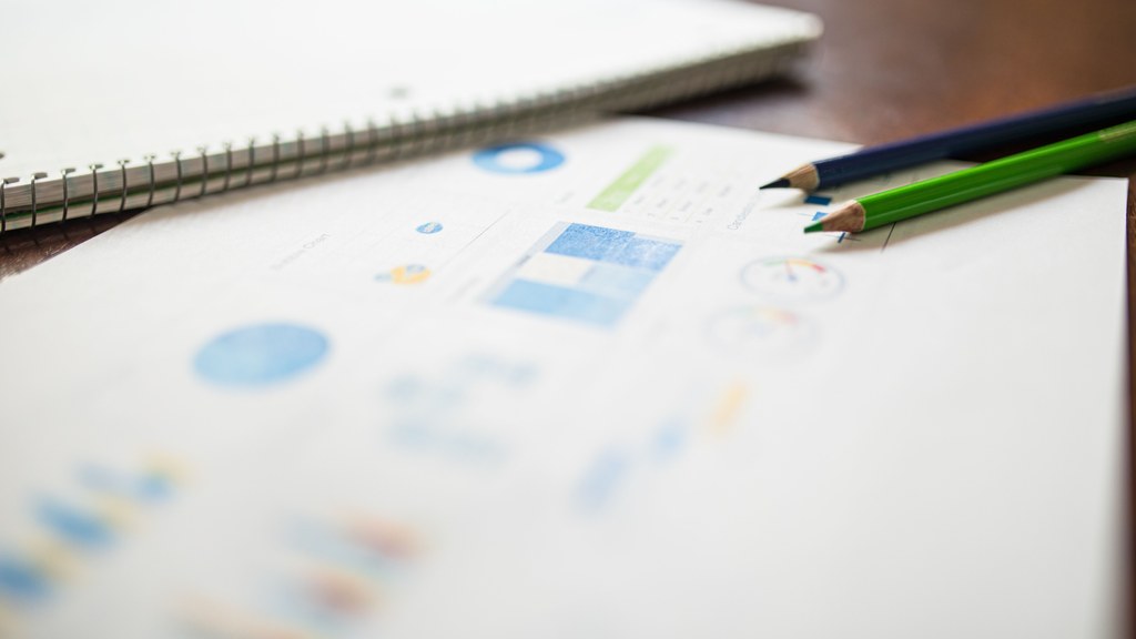 Close-up of colored pencils on an analytics report for education or business purposes.