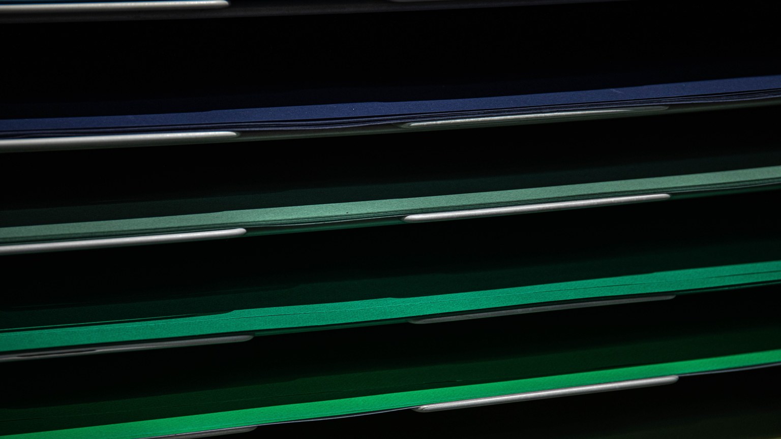 Close-up view of assorted colored paper in a stacking rack, perfect for school or office use.