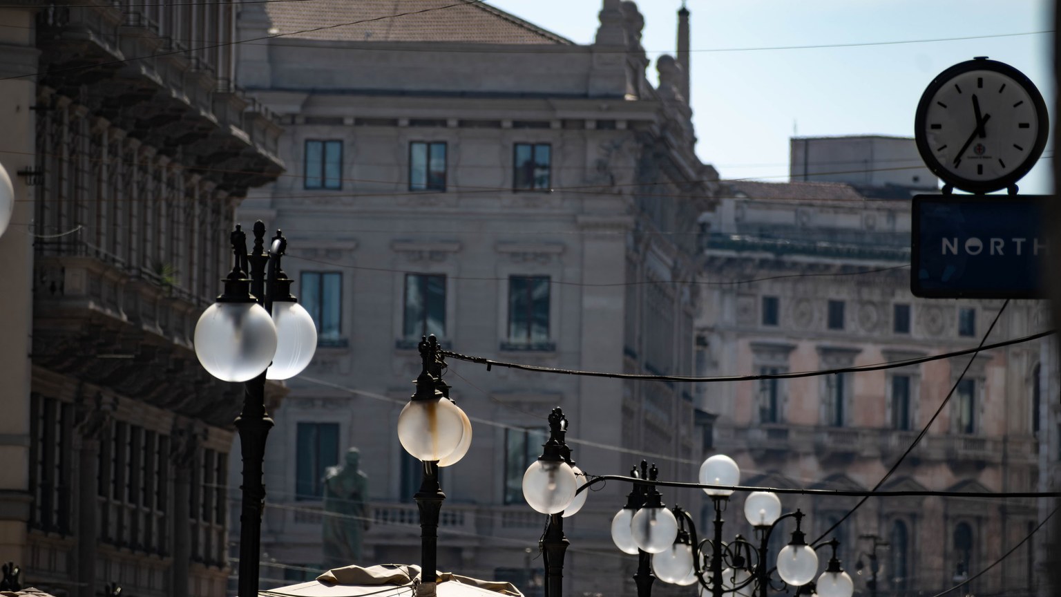Historic architecture in Milan with decorative lamp posts lining elegant streets.