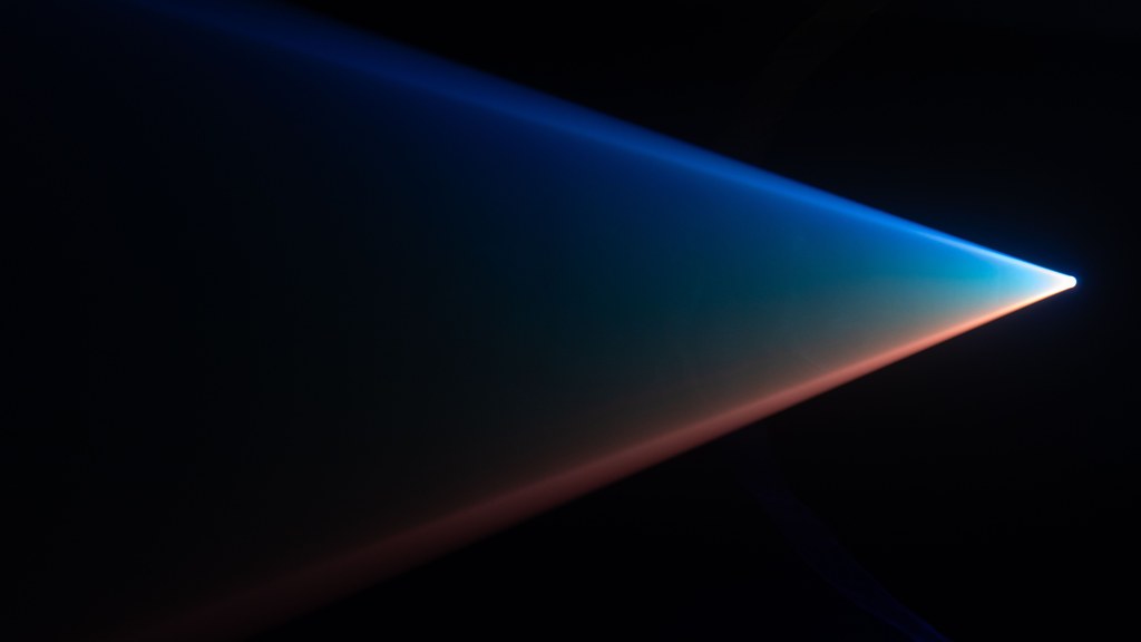 Vibrant light beam against a dark backdrop creating an abstract visual art piece.