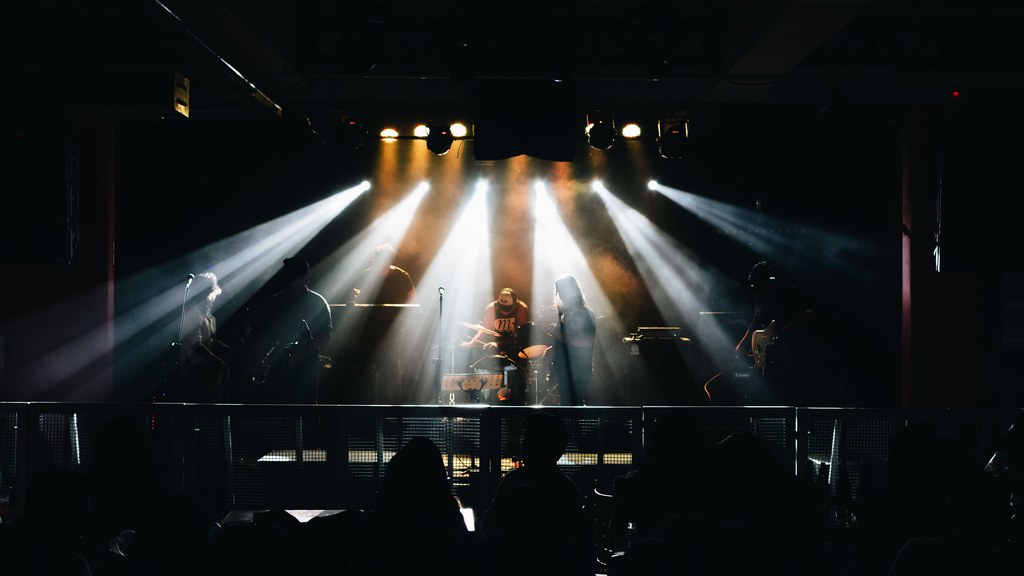 A vibrant live music concert in Lima, Peru, featuring musicians on stage with dramatic lighting.