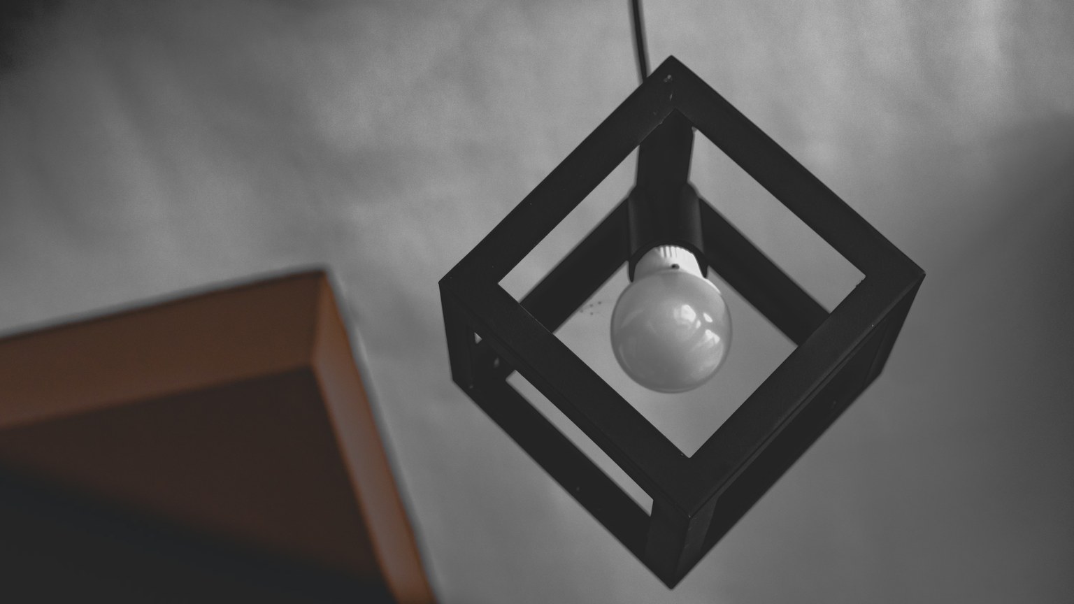 Minimalist geometric lamp with a cube frame, offering a modern, stylish vibe.
