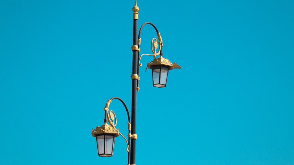 Vintage street lamp with ornate details set against a clear blue sky.