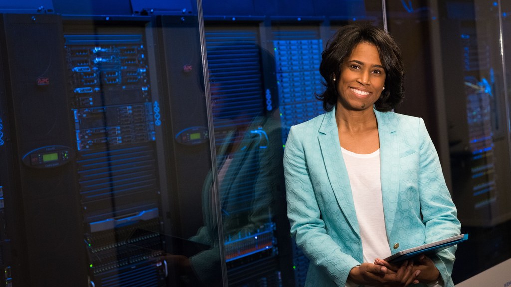 Smiling woman in data center showcasing technology expertise.