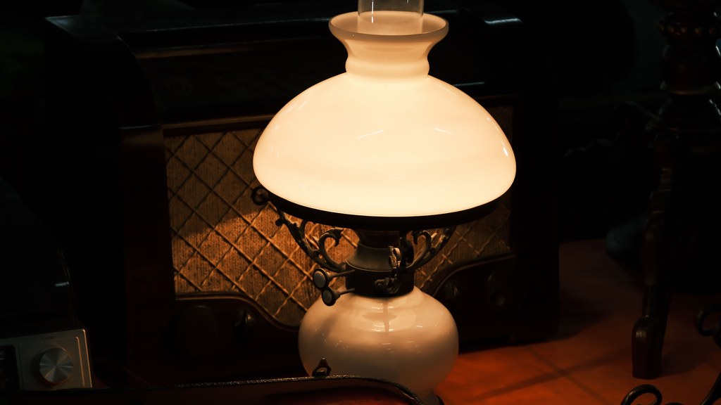 Elegant vintage oil lamp glowing warmly indoors, creating a nostalgic ambiance.