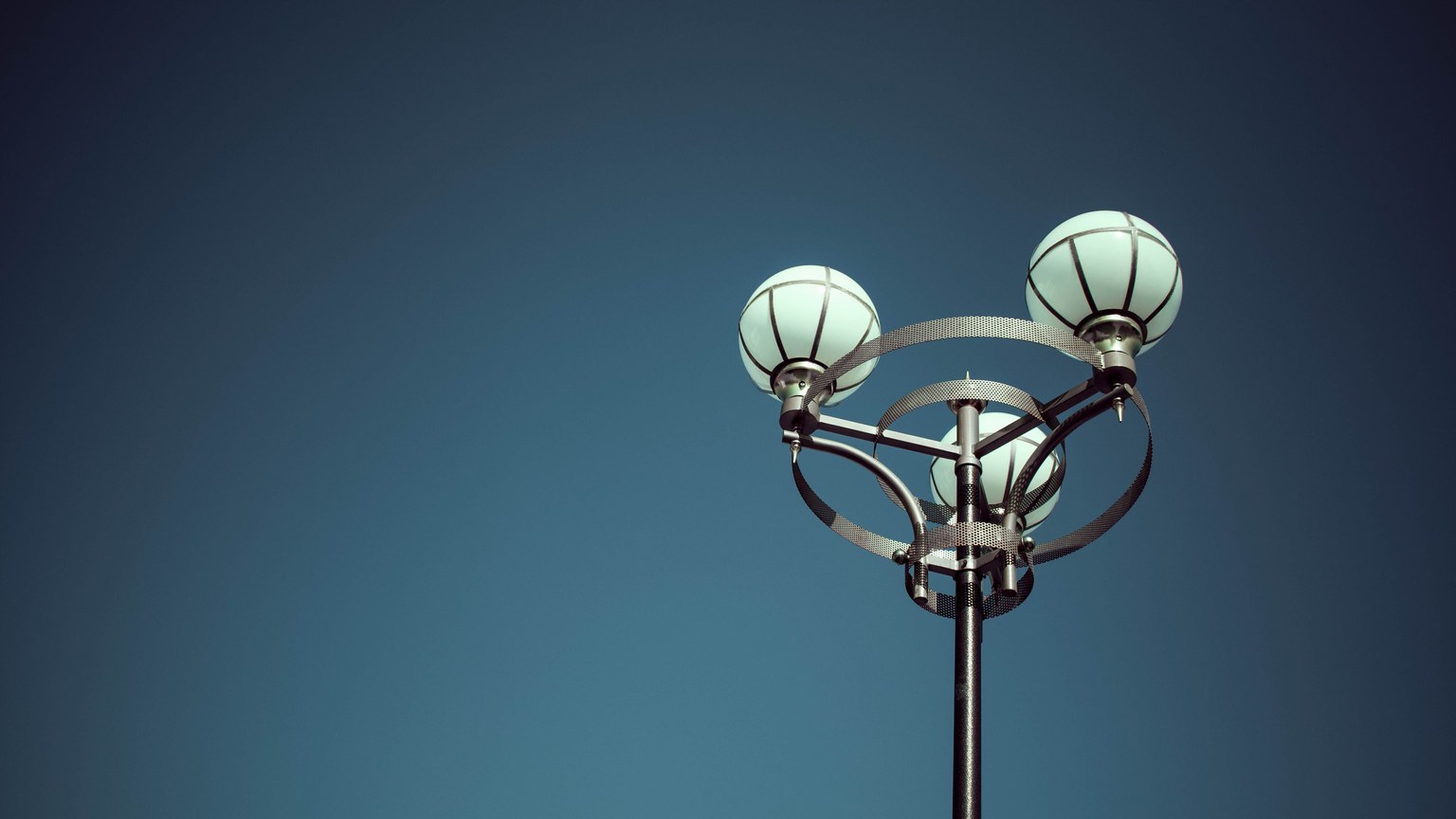 A classic street lamp set against a clear blue sky with ample copy space.