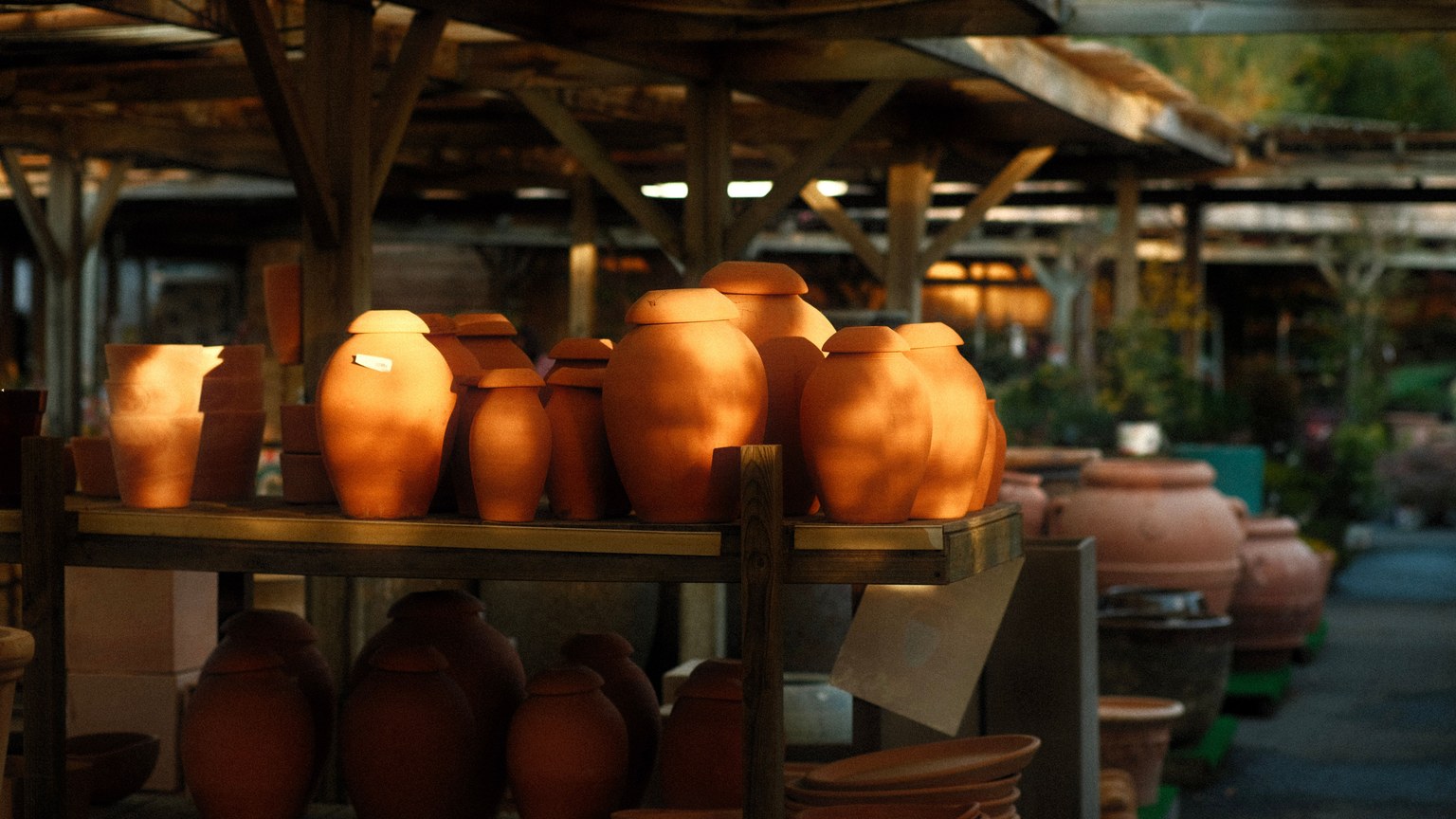 Beautiful handmade terracotta pots displayed on shelves in an outdoor market, showcasing artisanal craftsmanship.