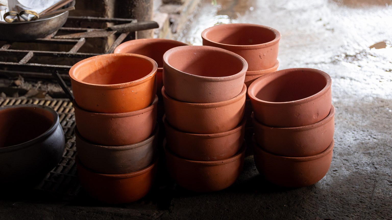 A stack of traditional terracotta pots in a Vietnamese pottery workshop, illustrating local craftsmanship.