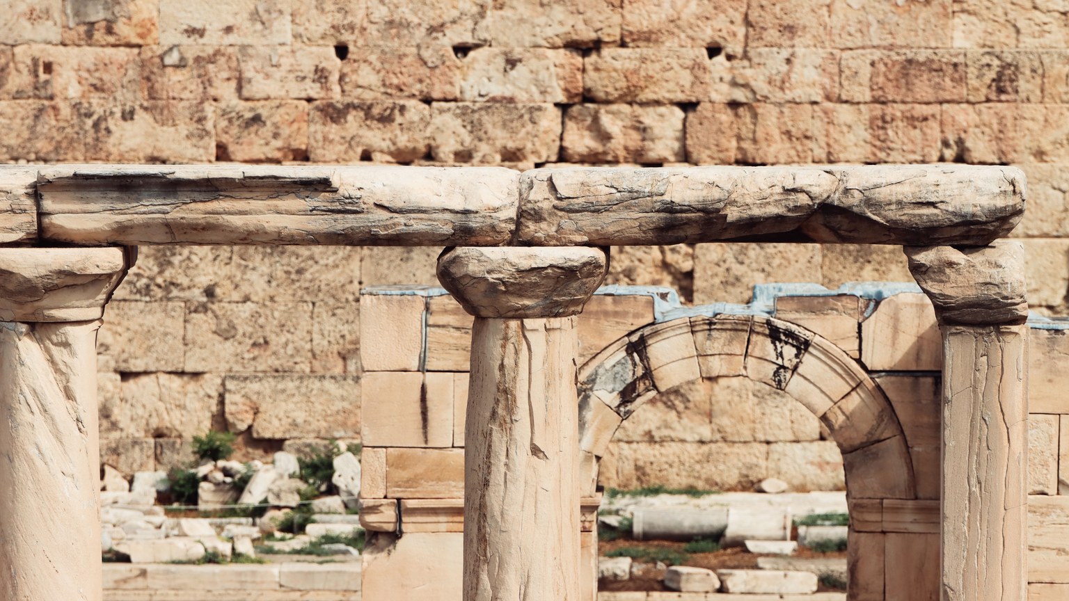 Detailed view of ancient stone columns and arches in Athens, showcasing Greek architecture.
