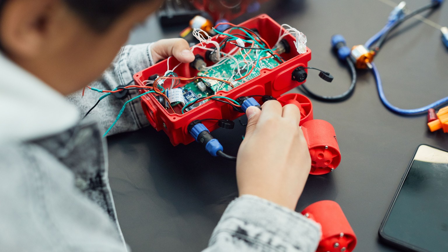 A child actively assembling a robotics project with electronic components, showcasing technology education.