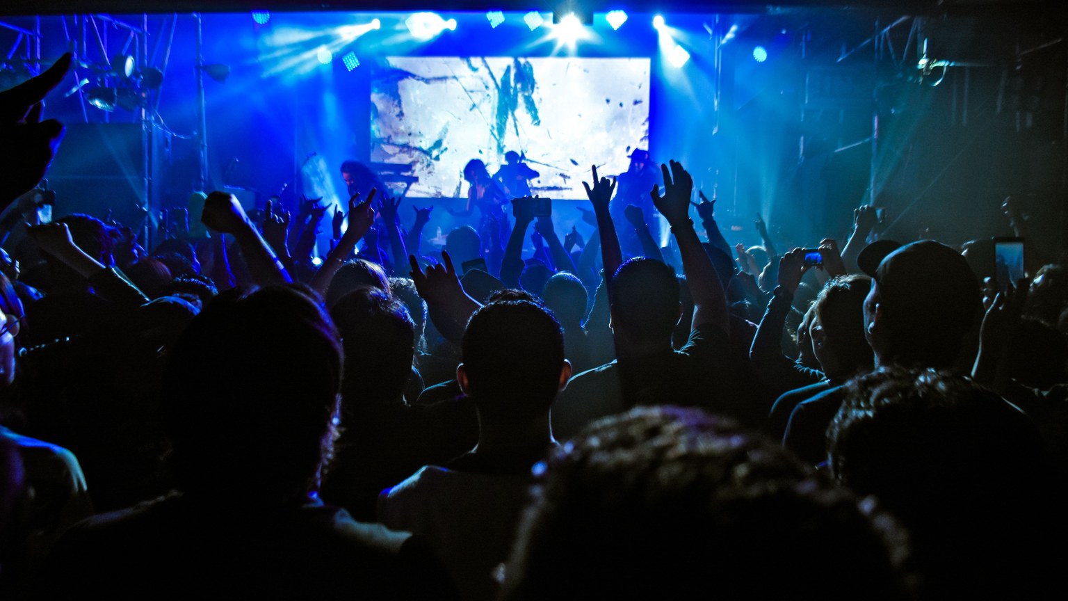 Crowd enjoying a dynamic live concert performance with vibrant lights in Guadalajara.