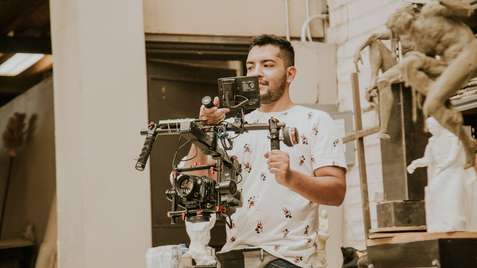 Videographer working with a professional stabilizing rig indoors, capturing behind-the-scenes moments.