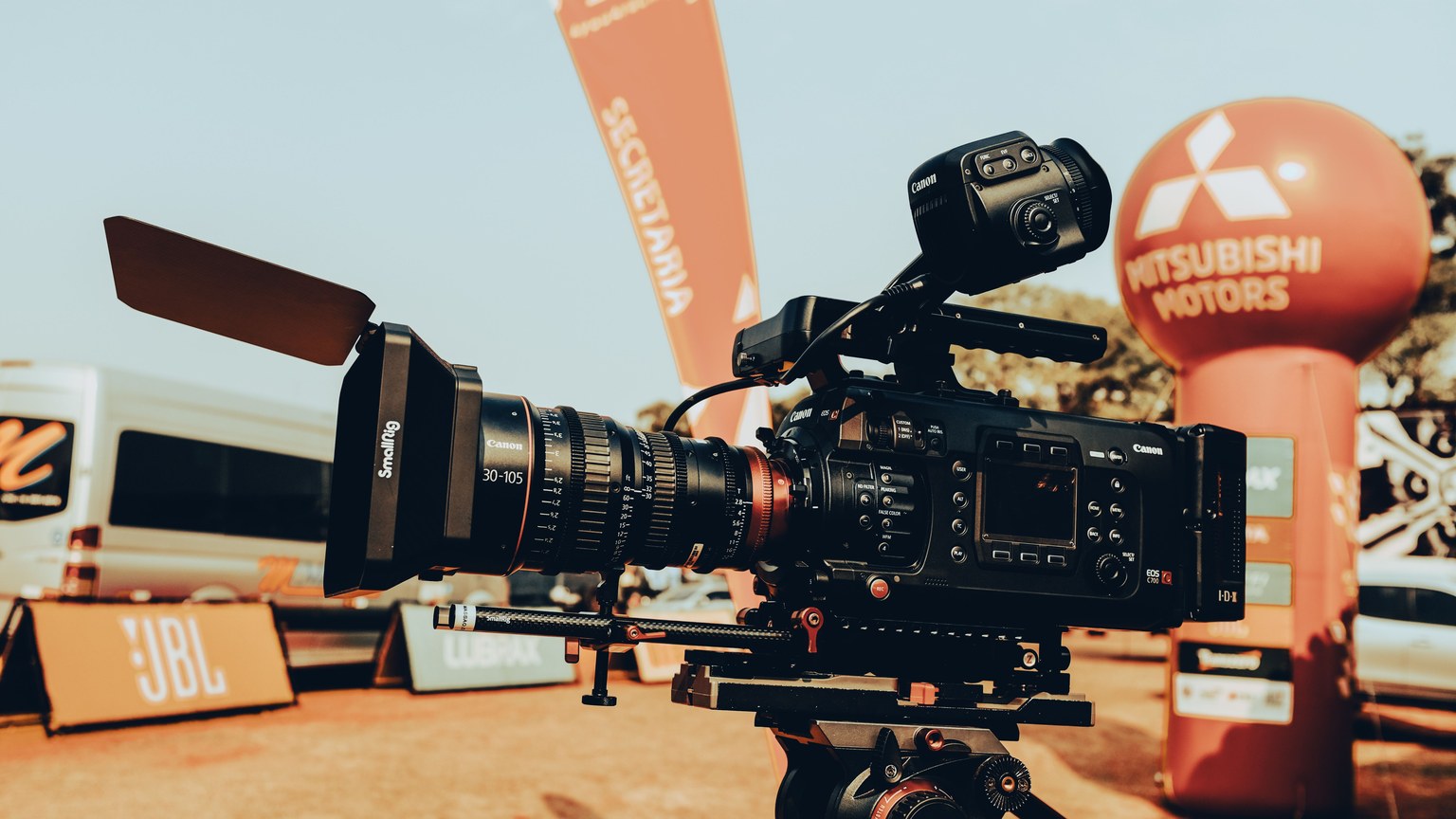 High-end video camera setup at an outdoor car event, displaying advanced filming equipment.