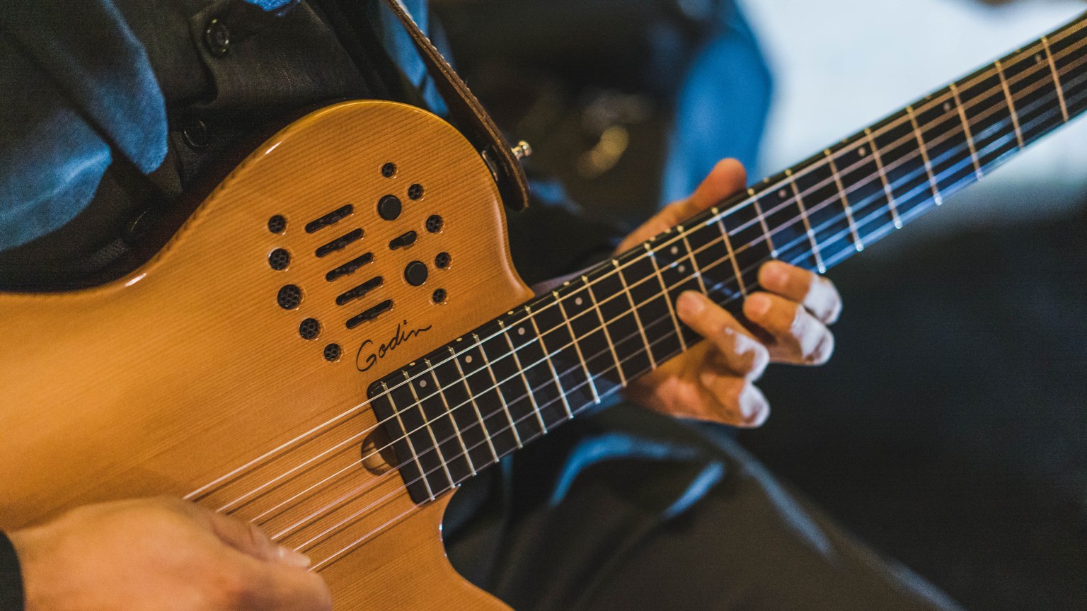 Musician skillfully playing an electric guitar with focus on hands and strings.