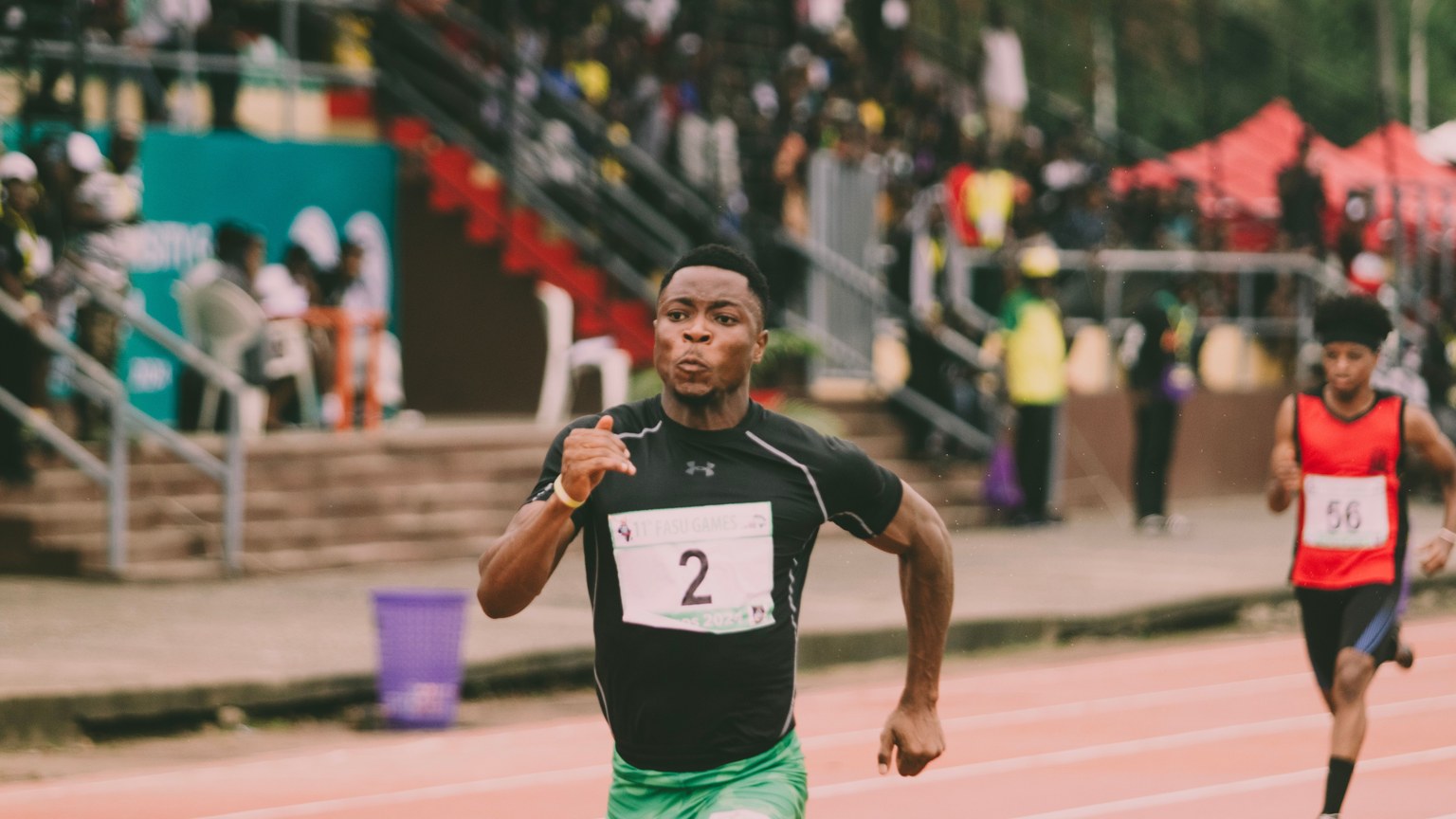 Athlete in green shorts sprinting on track, racing towards victory