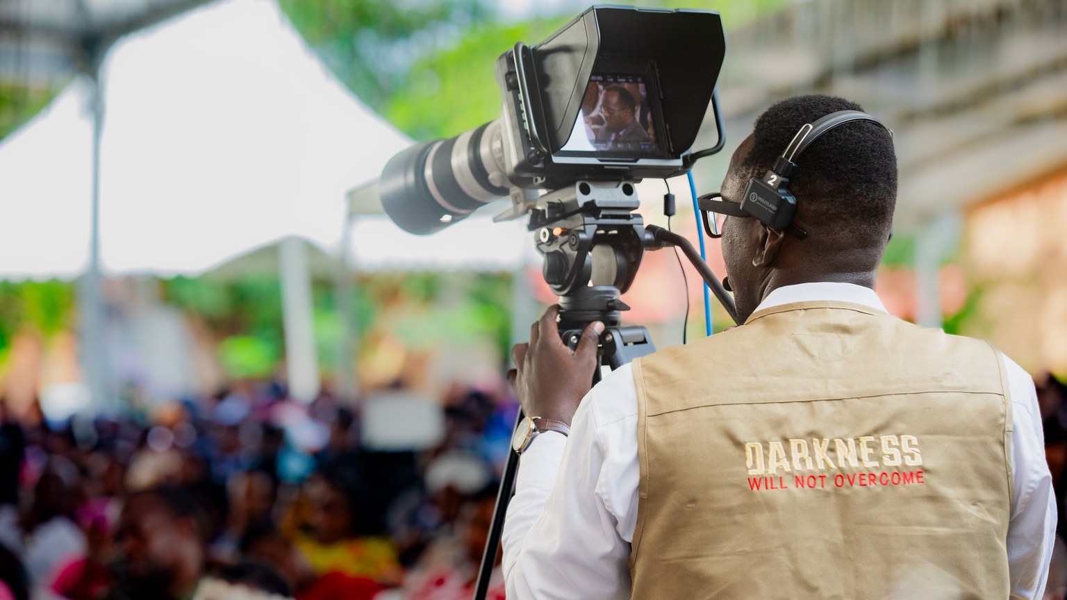 Cameraman filming an outdoor event in Dar es Salaam, Tanzania.