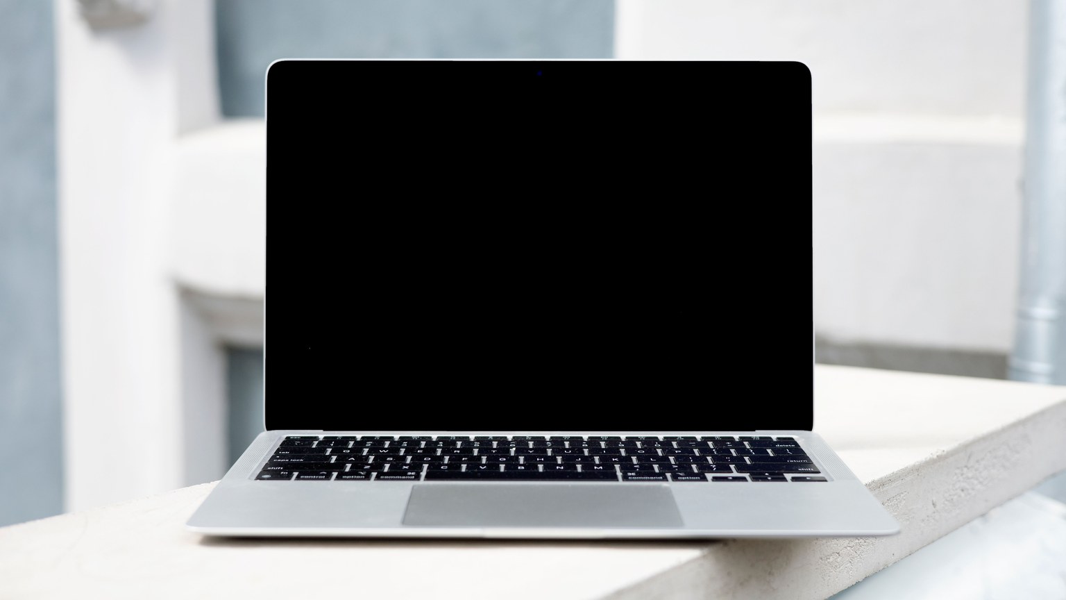A sleek laptop with a blank screen on a white surface, perfect for digital mockups.