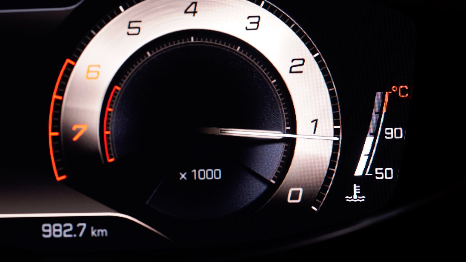 Close-up view of a car's RPM gauge on the dashboard with clear readings.