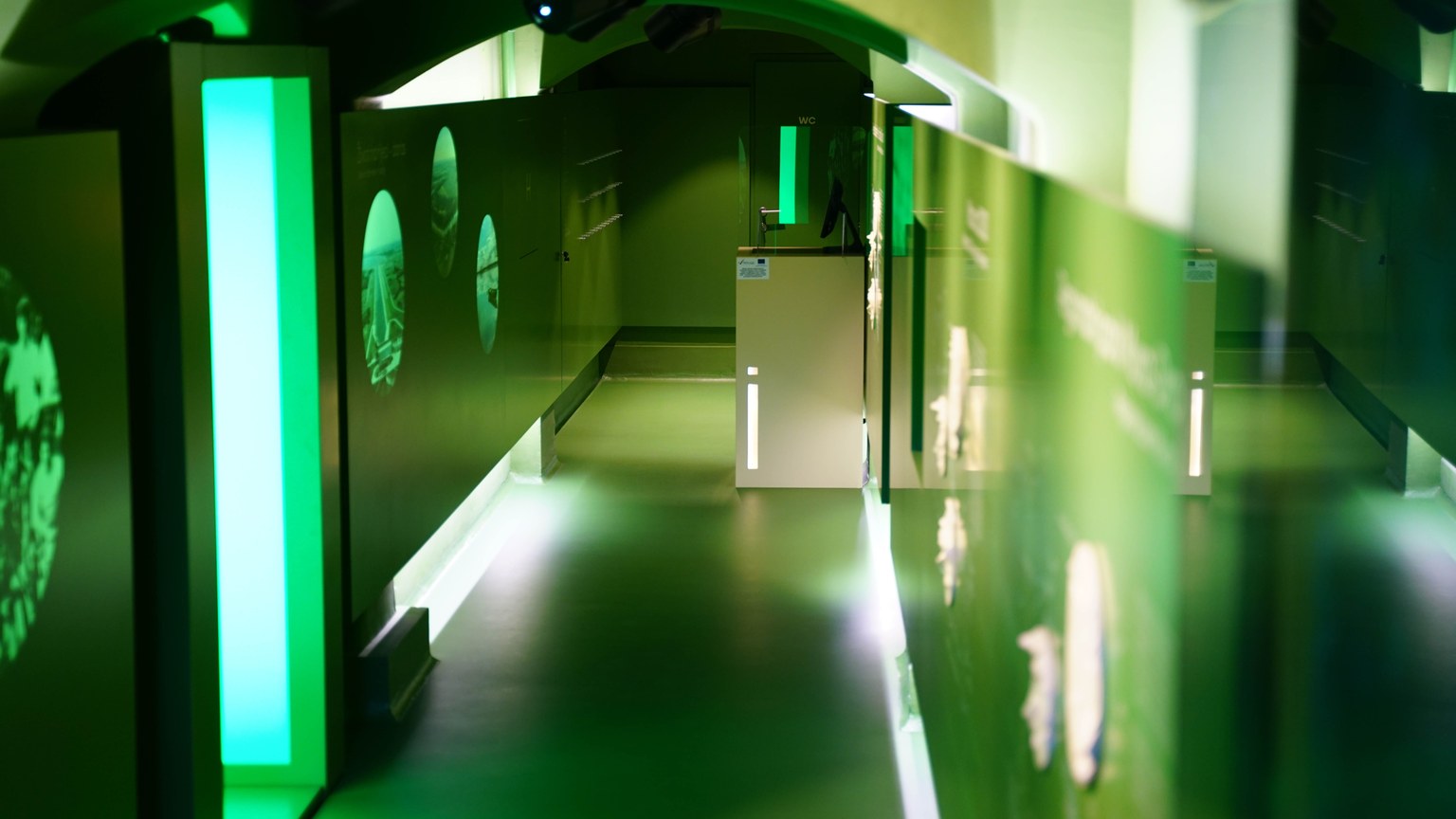 Explore a futuristic corridor with vibrant green lighting and modern design elements.