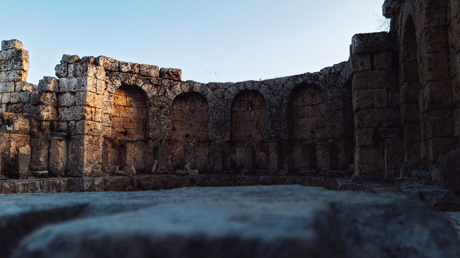 Explore the ancient Roman ruins in Antalya, Türkiye, captured in the warm glow of dusk.