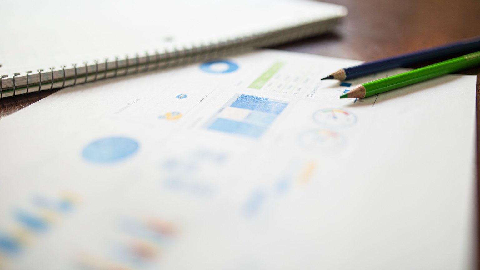 Close-up of colored pencils on an analytics report for education or business purposes.