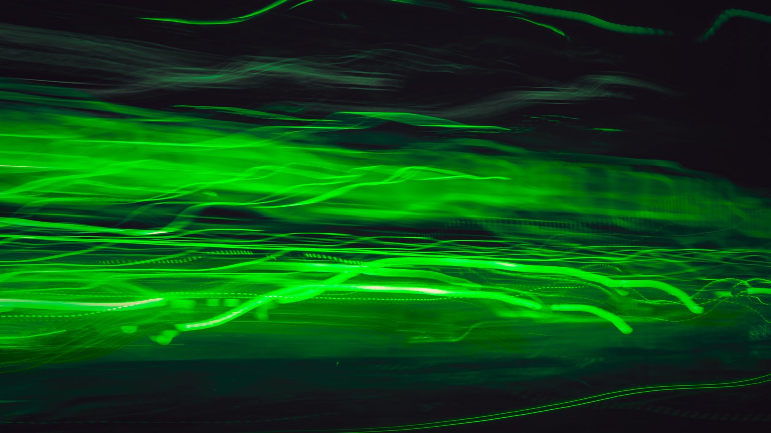 Dynamic abstract image of vibrant green light trails in motion, creating a futuristic feel.