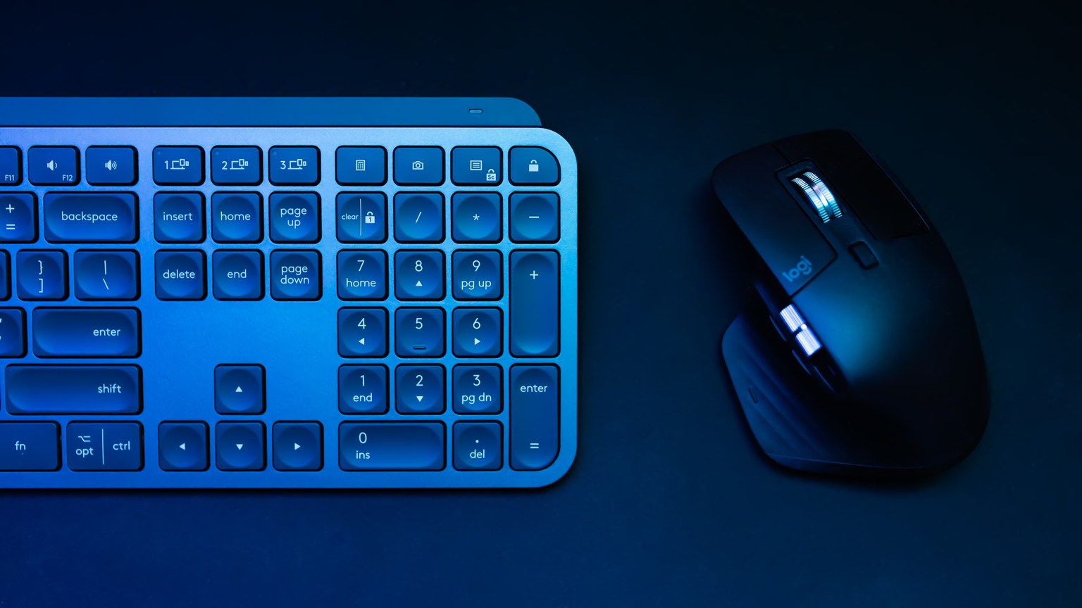 Sleek blue-lit wireless keyboard and mouse, ideal for tech themes.