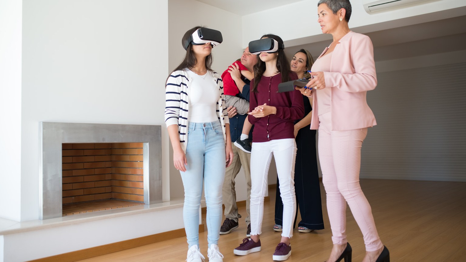 Family experiencing virtual reality house tour guided by a realtor indoors.