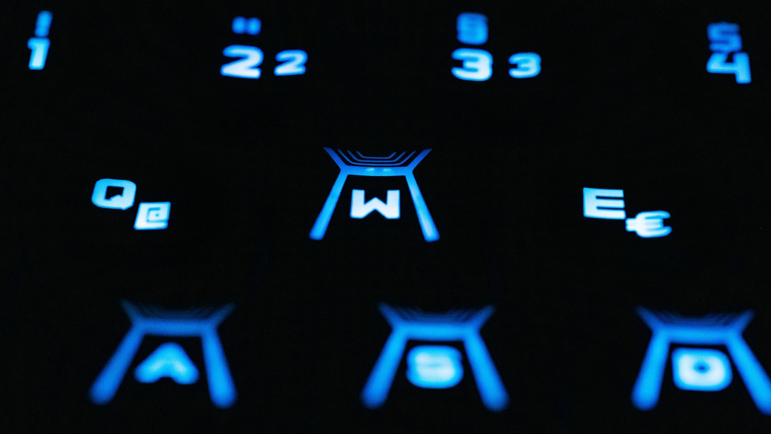 A closeup view of a blue backlit keyboard highlighting numbers and symbols.