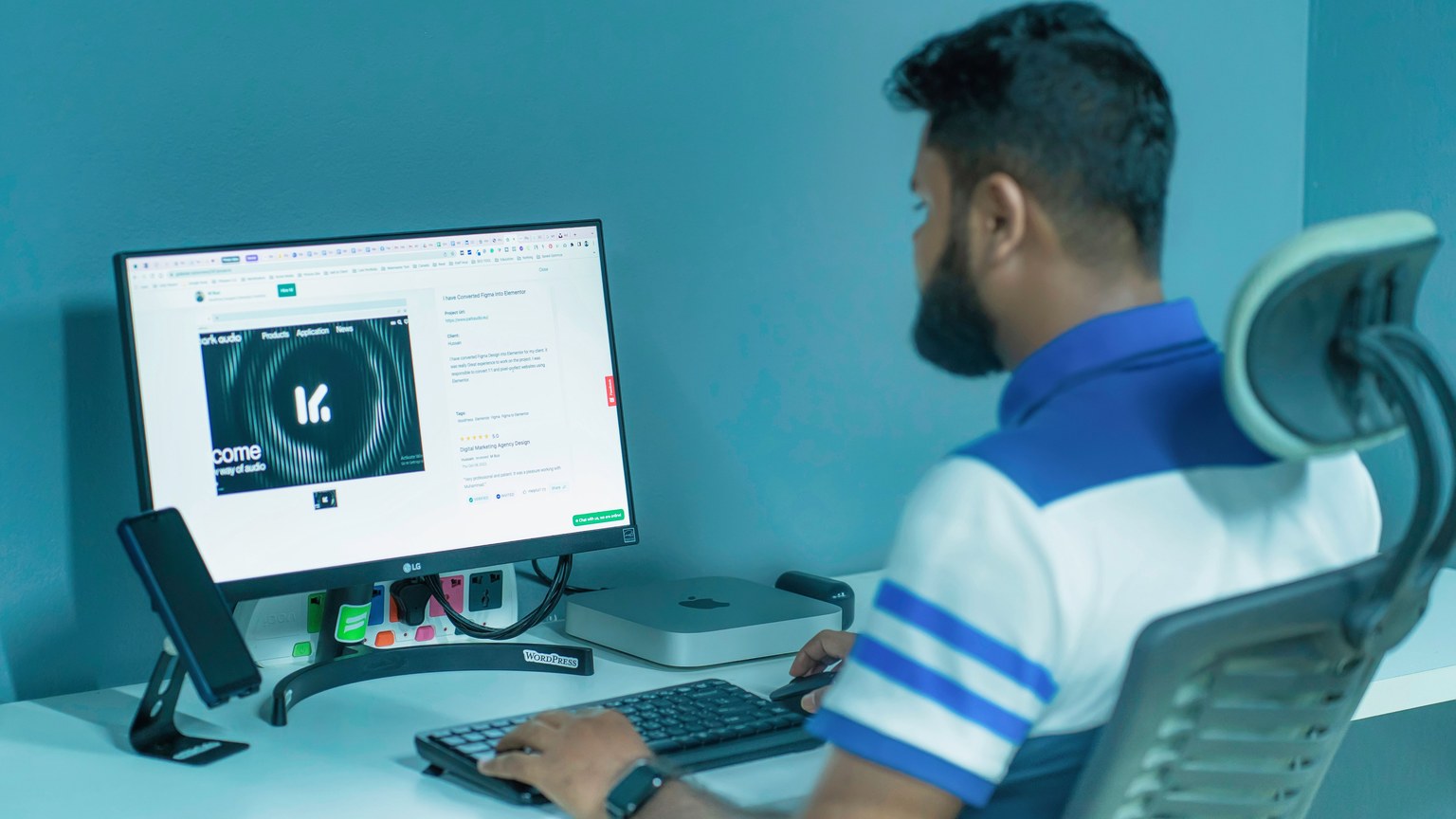 Man using a desktop computer with modern tech setup in a professional office environment.