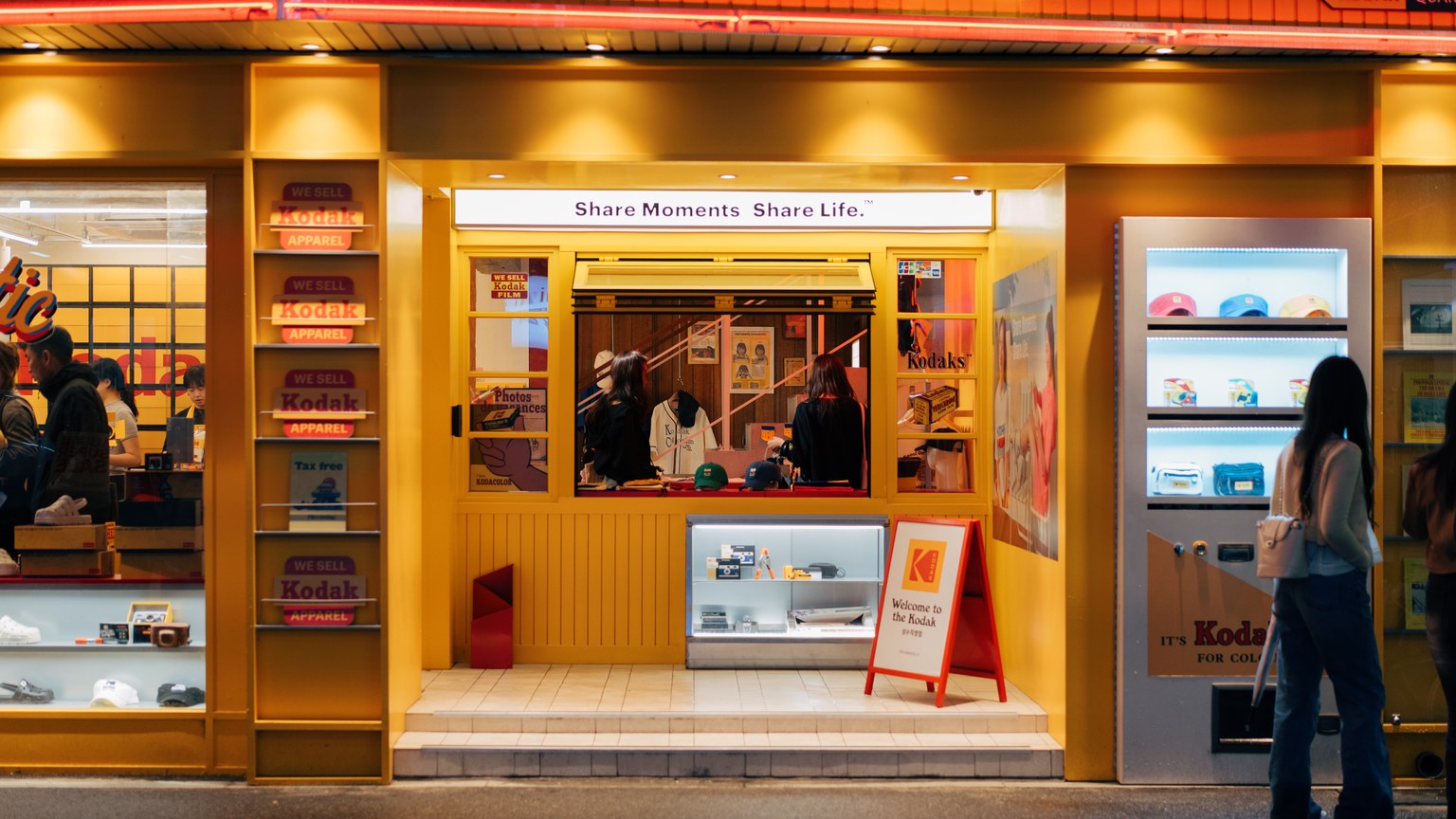 Vibrant Kodak store entrance at night in South Korea, showcasing retro and modern photography items.