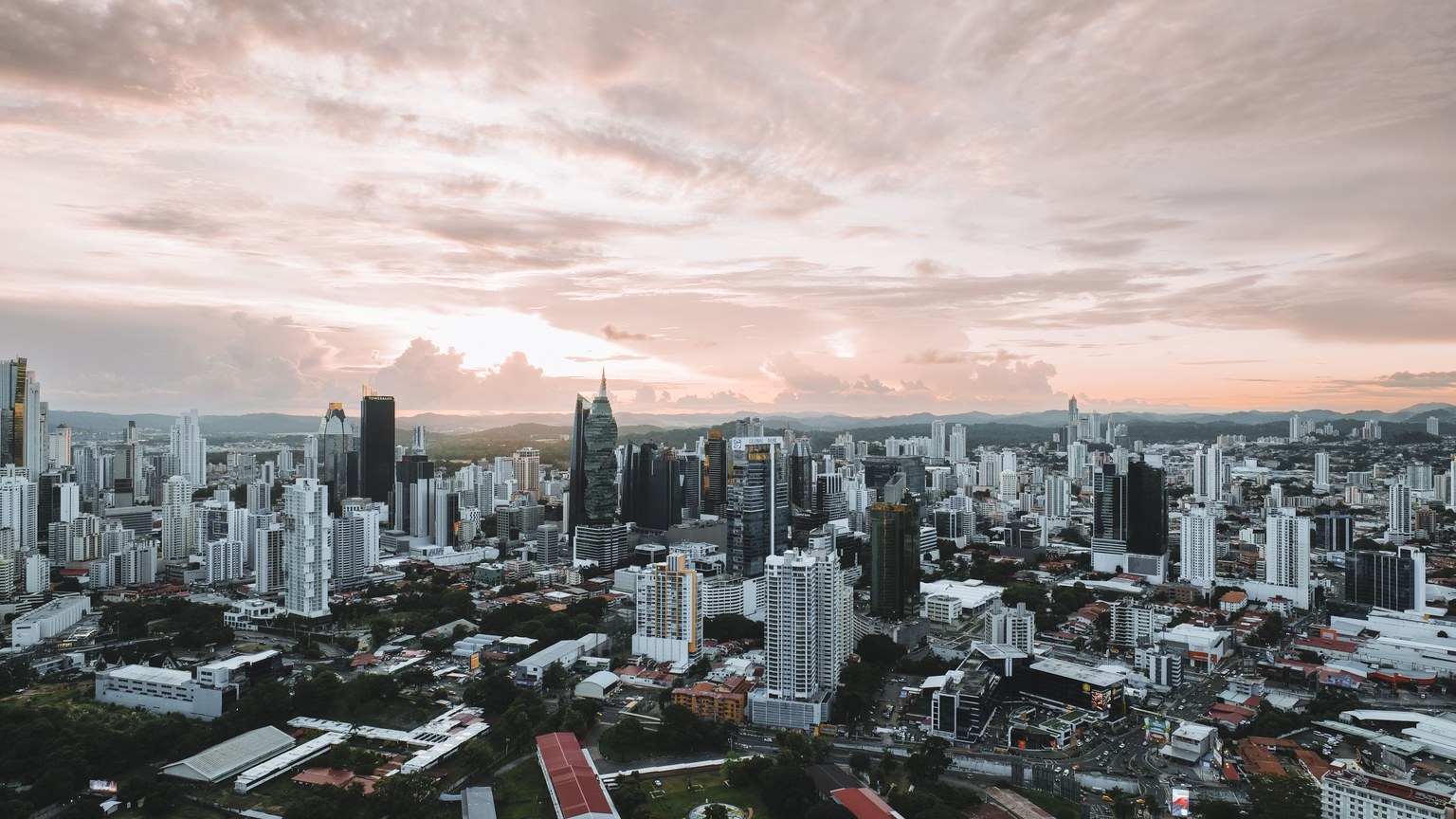 Dramatic aerial view of Panama City skyline during sunset showcasing modern skyscrapers.