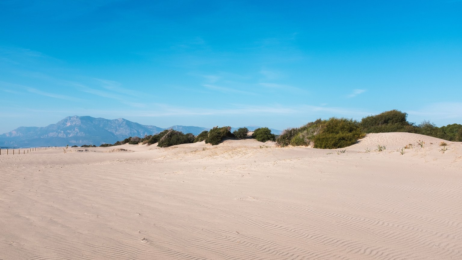 Expansive sand dunes under a clear blue sky at Patara Beach, Turkey, showcasing natural beauty.