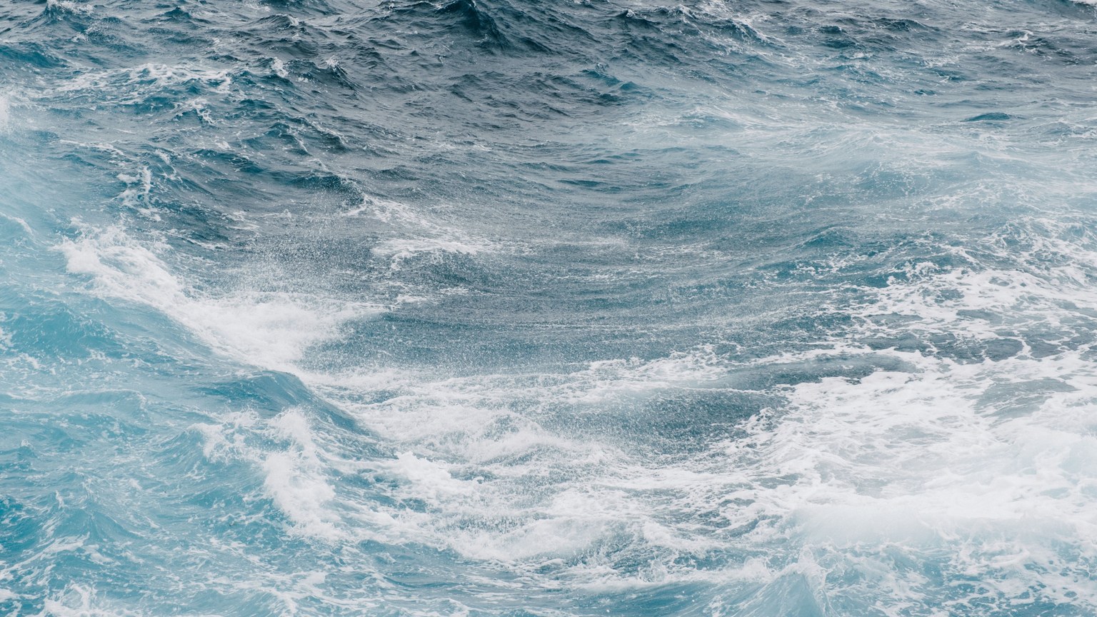 Vibrant and powerful ocean waves crashing and swirling in the sea, showcasing nature's beauty and energy.