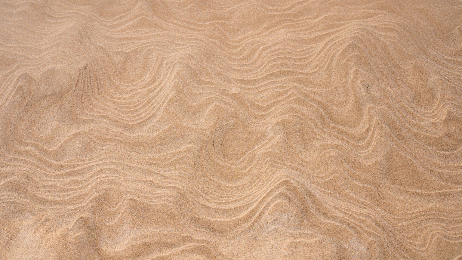 Close-up view of rippled sand texture at Leba Beach, Poland, showcasing natural patterns.