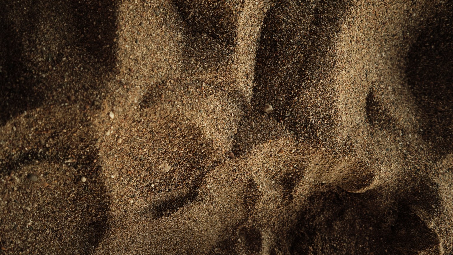 Detailed texture of sand on a beach in Antalya, capturing natural patterns and earthy tones.