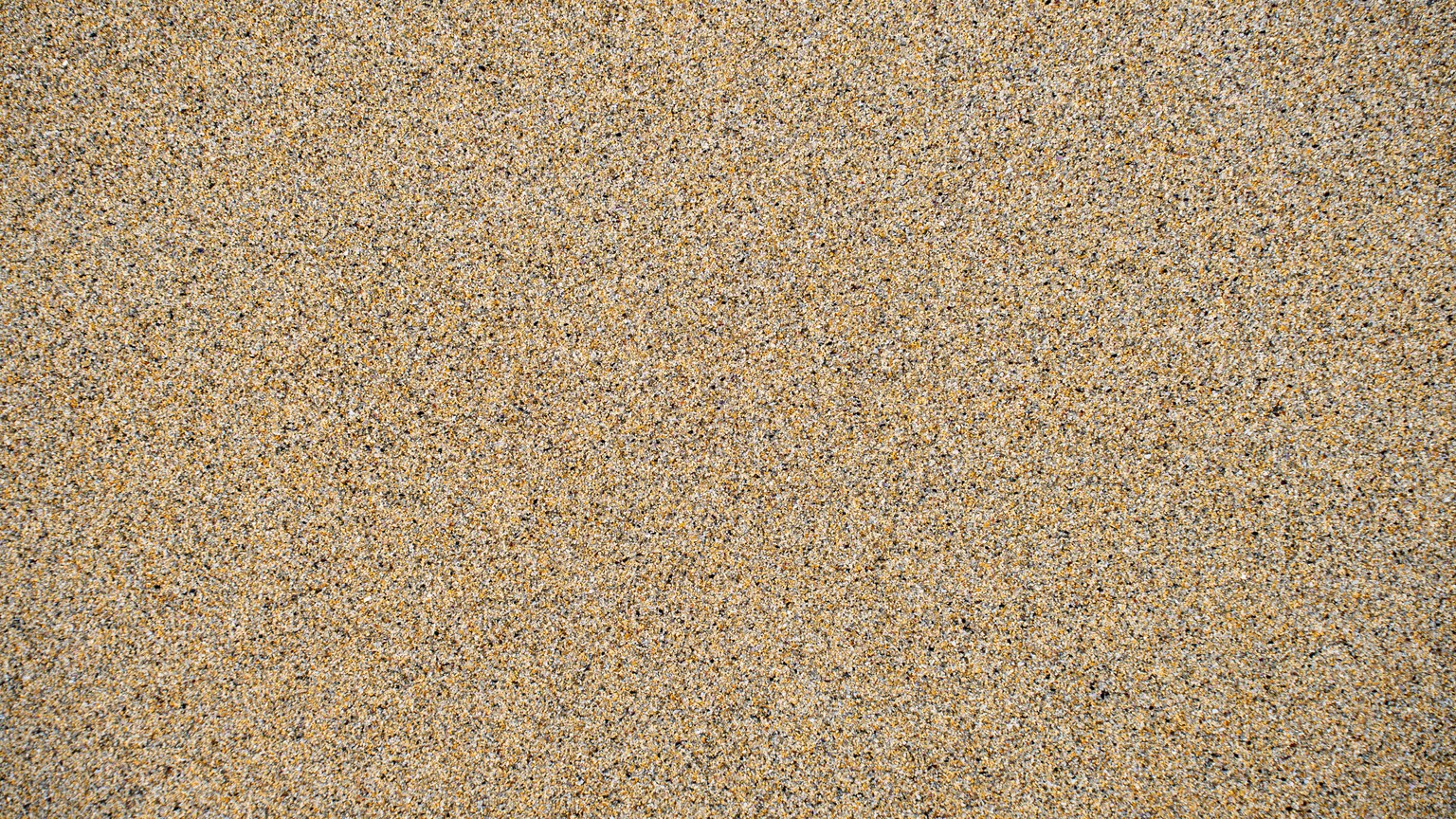 Detailed close-up of textured sand on a beach in Harris, Scotland, perfect for backgrounds.