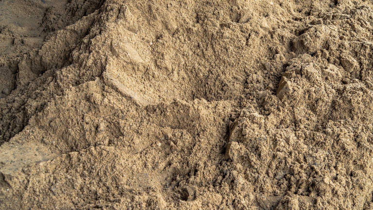 Detailed texture of coarse sand dunes, perfect for backgrounds and design elements.