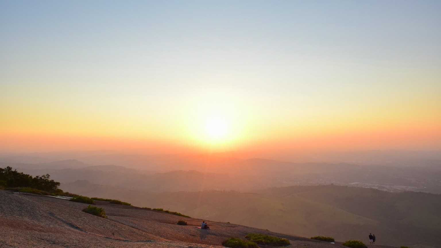 A breathtaking sunrise over a vast mountainous landscape with clear skies.