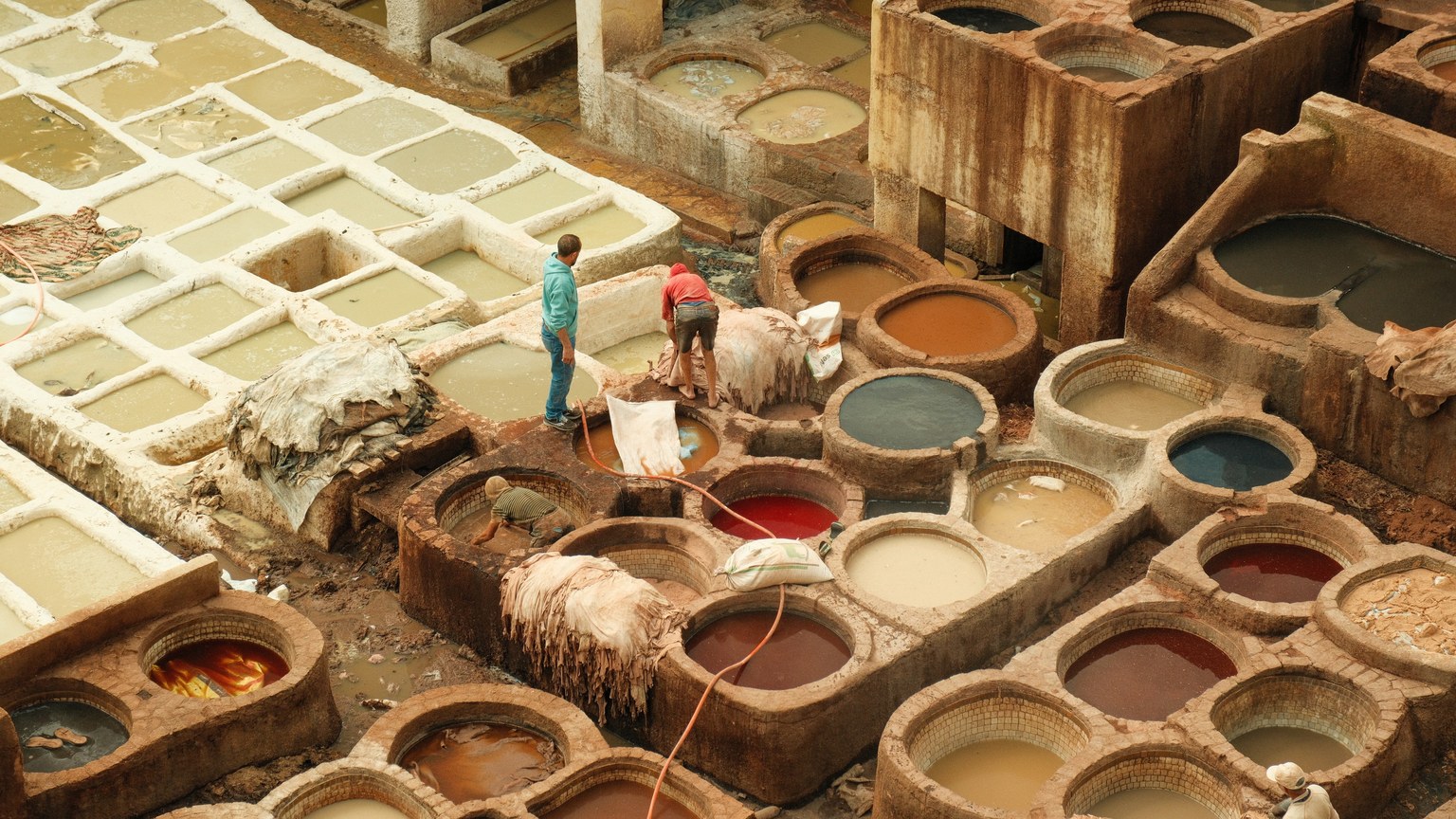 Aerial view of a traditional leather tannery in Fes, Morocco, showcasing colorful dye pits.