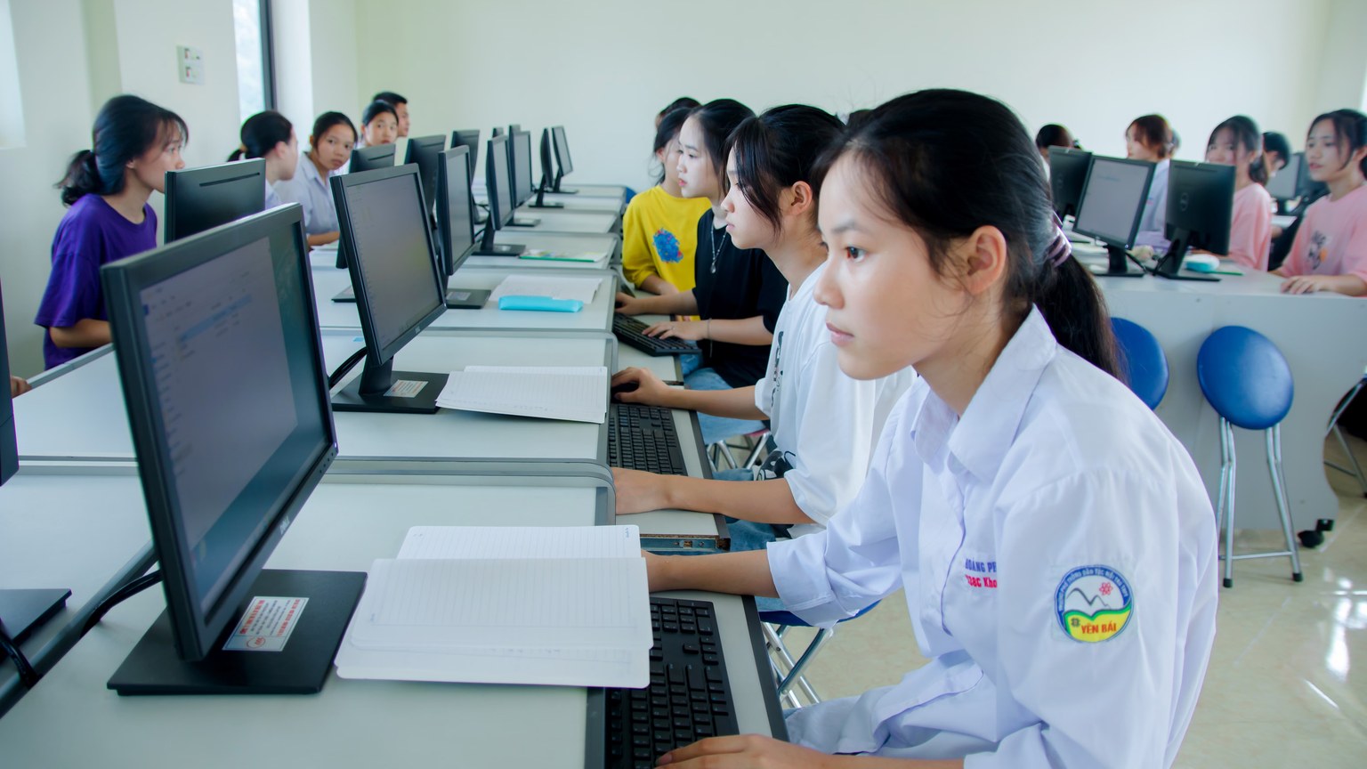Students engaged in study at a computer lab, focused on technology and teamwork.