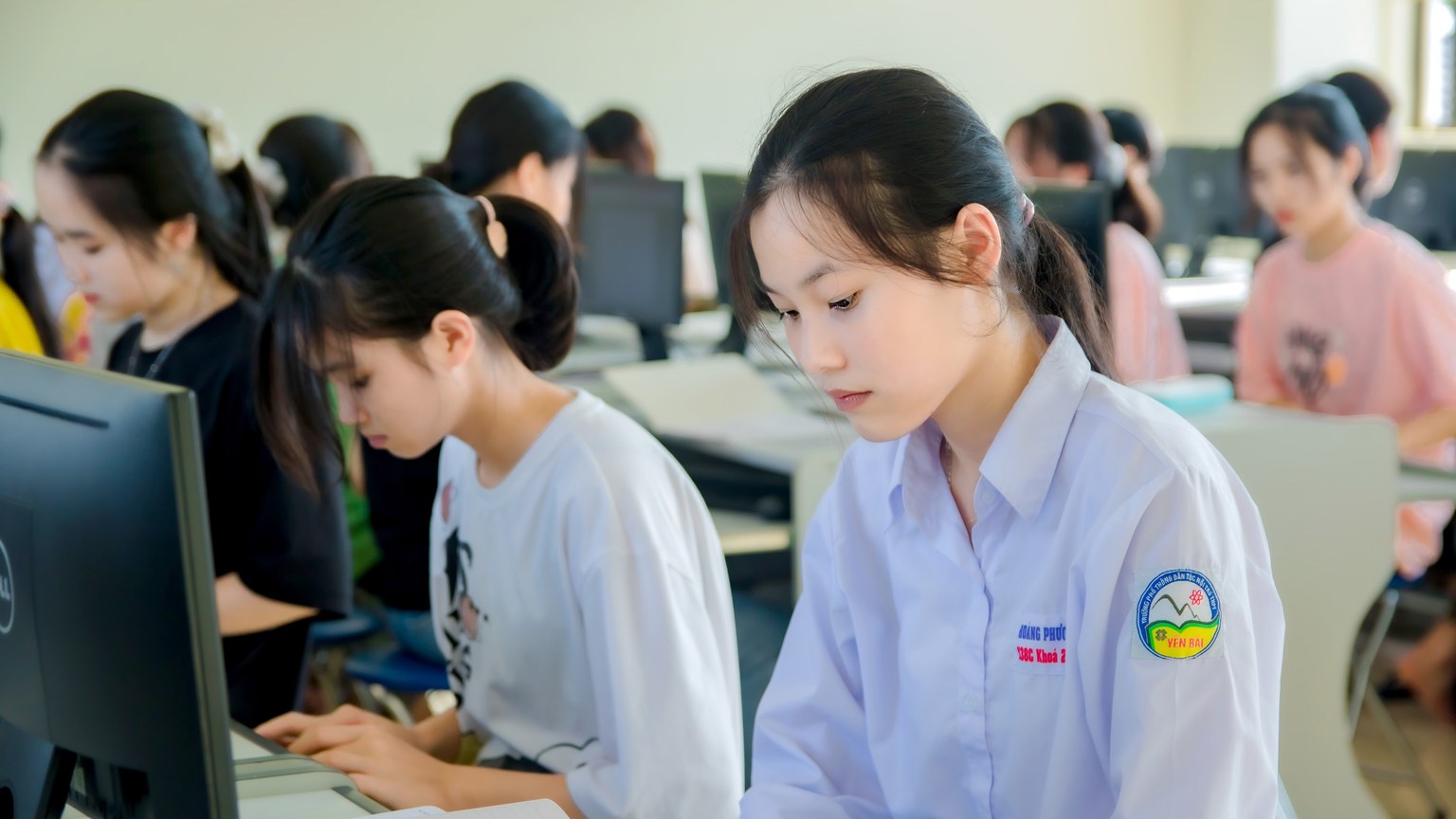 Young Asian women focused on studying in a university computer lab.