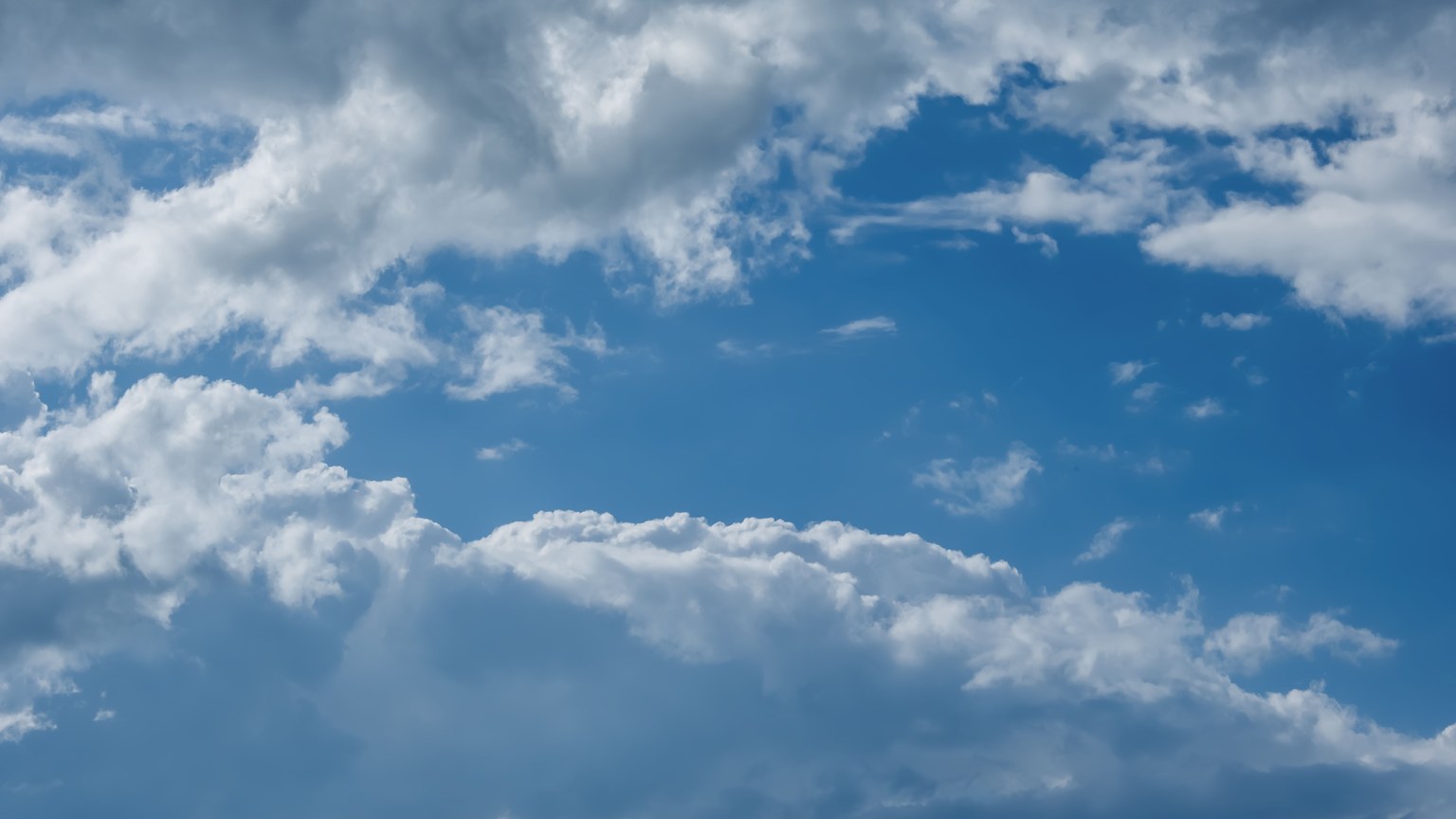 Vibrant blue sky with white clouds over Freiburg, Germany, showcasing natural beauty.