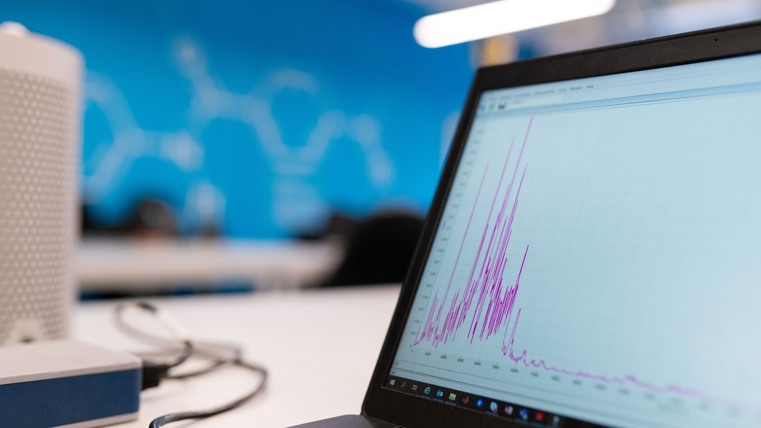 Laptop displaying data analytics graph in a modern office setting, symbolizing growth and technology.