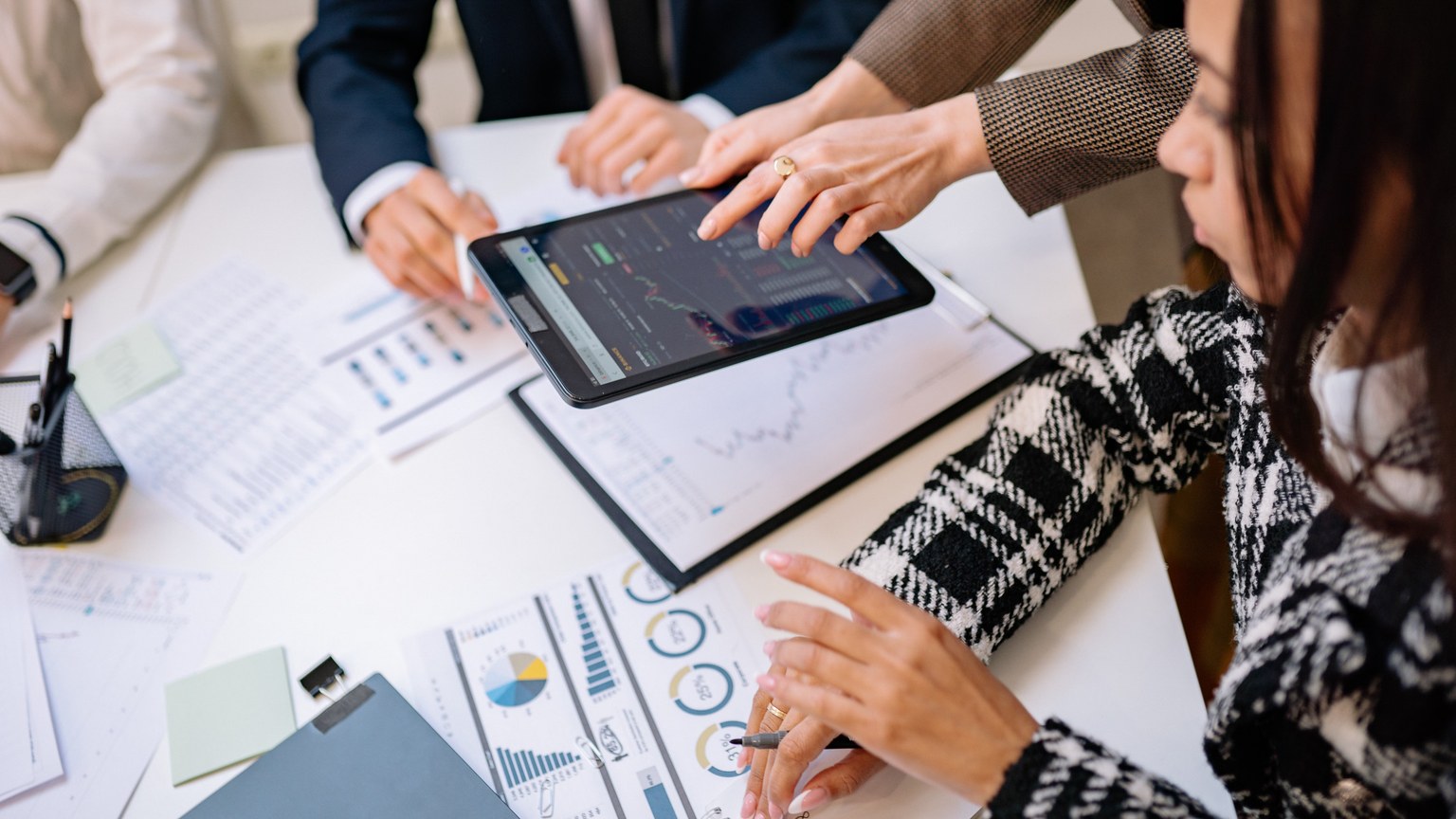 Business professionals reviewing analytics on a tablet during a meeting.